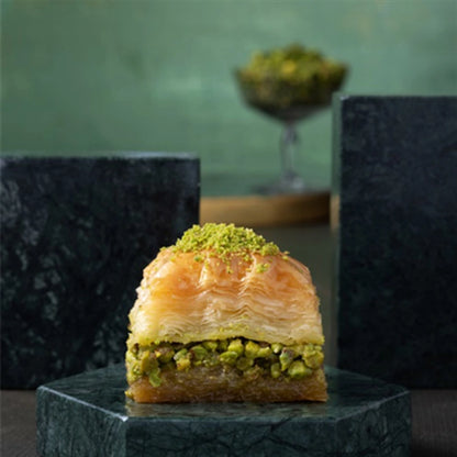 Dry pistachio baklava piece on dark slate
